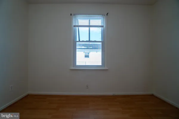 a view of a small space with wooden floor and a window