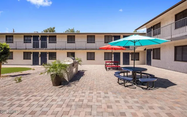 a view of a patio with a table and chairs under an umbrella