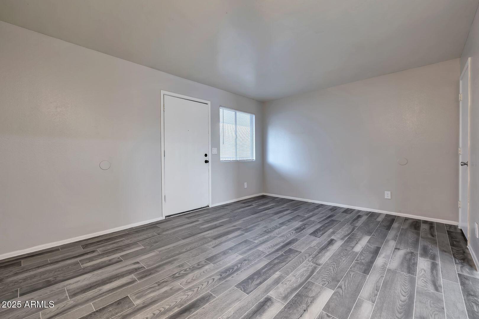 2216 East Eugie Terrace, Unit 207 Phoenix, AZ 85022 - Photo 2 of 7 a view of an empty room and wooden floor