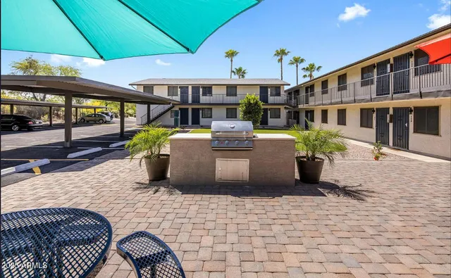 a view of a patio with a table and chairs under an umbrella