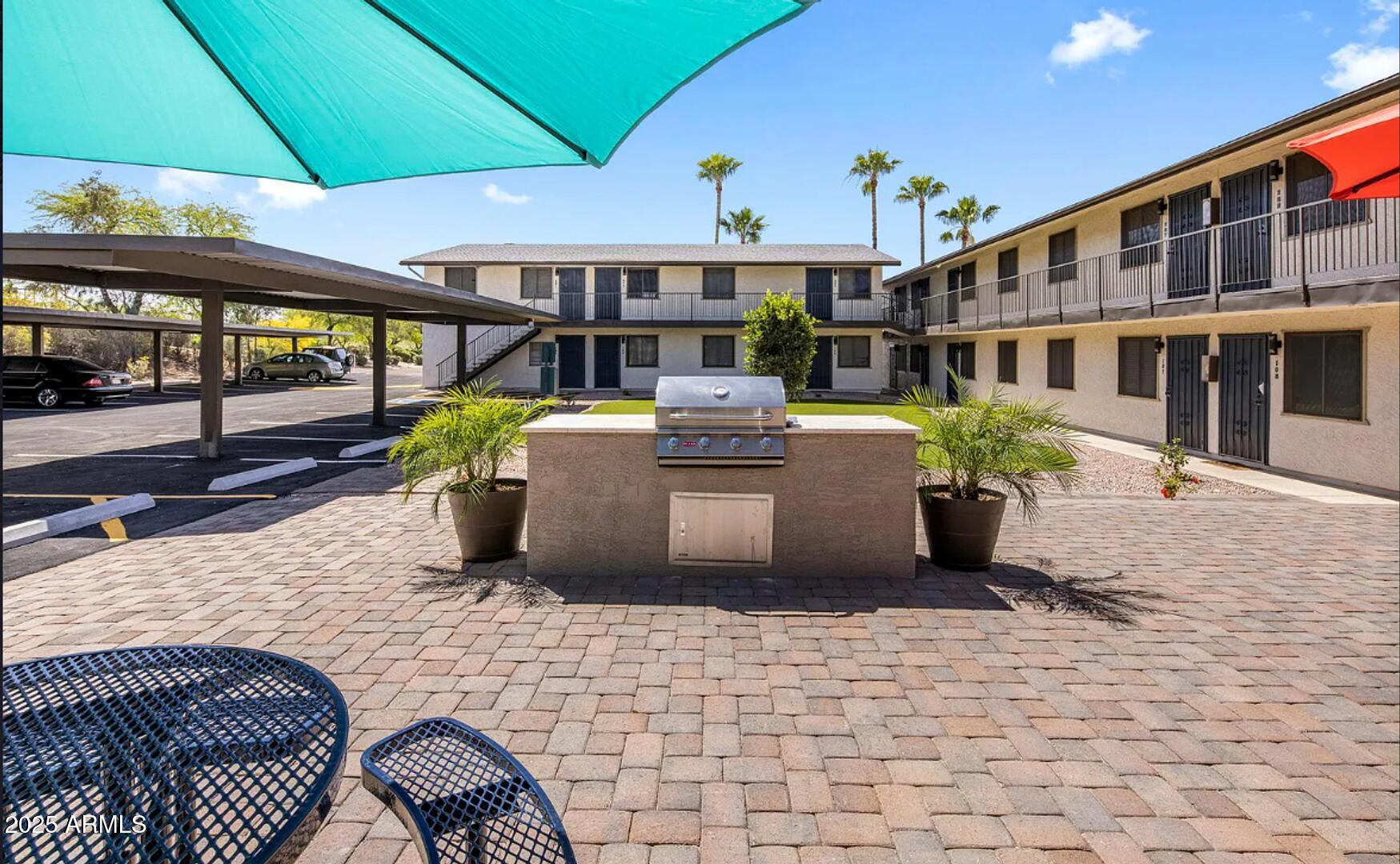 2216 East Eugie Terrace, Unit 207 Phoenix, AZ 85022 - Photo 6 of 7 a view of a patio with a table and chairs under an umbrella