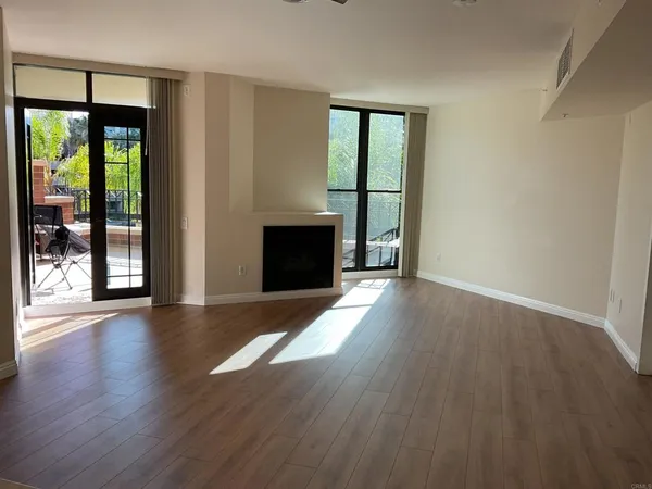 wooden floor fireplace and windows in an empty room