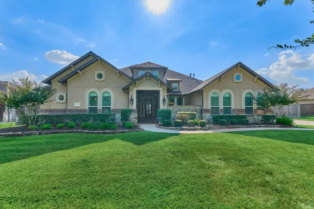 a view of a house with a big yard and large trees