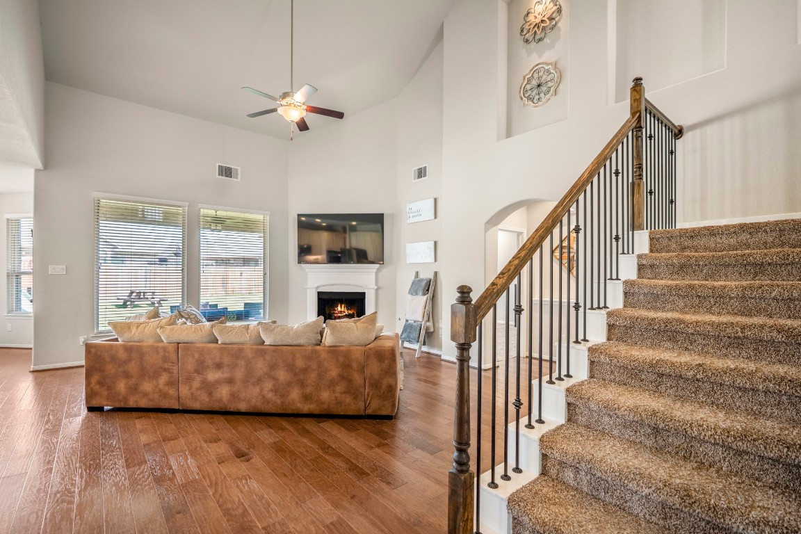 23006 Mulberry Tree Lane Spring, TX 77389 - Photo 11 of 50 The main living room features soaring ceilings, abundant natural light, and a cozy fireplace, all open to the kitchen and backyard views.