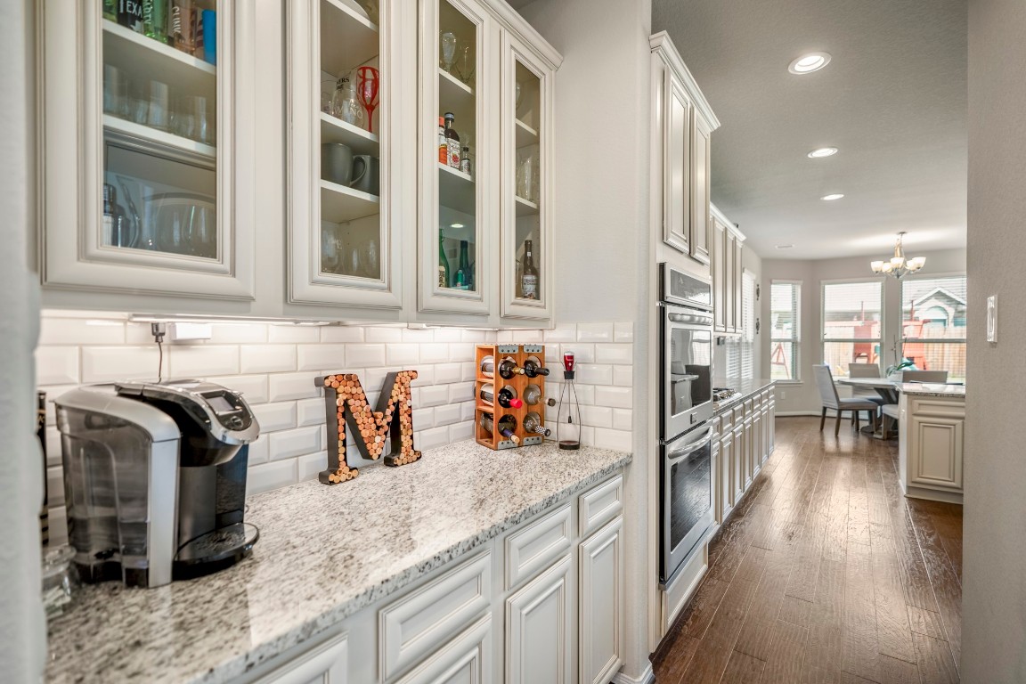 23006 Mulberry Tree Lane Spring, TX 77389 - Photo 17 of 50 A butler’s pantry with granite counters and glass-front cabinetry adds style and storage between the kitchen and dining room.