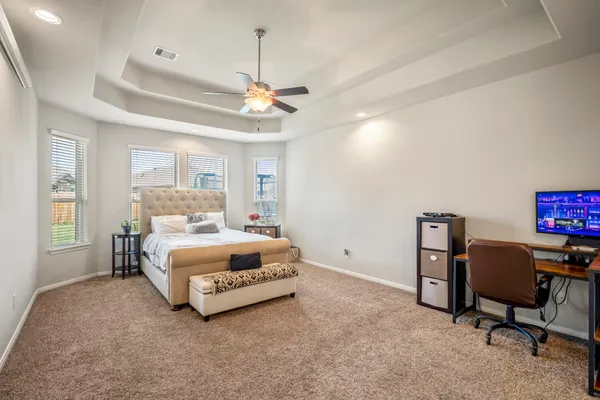 a bedroom with a bed gym equipment and a desk