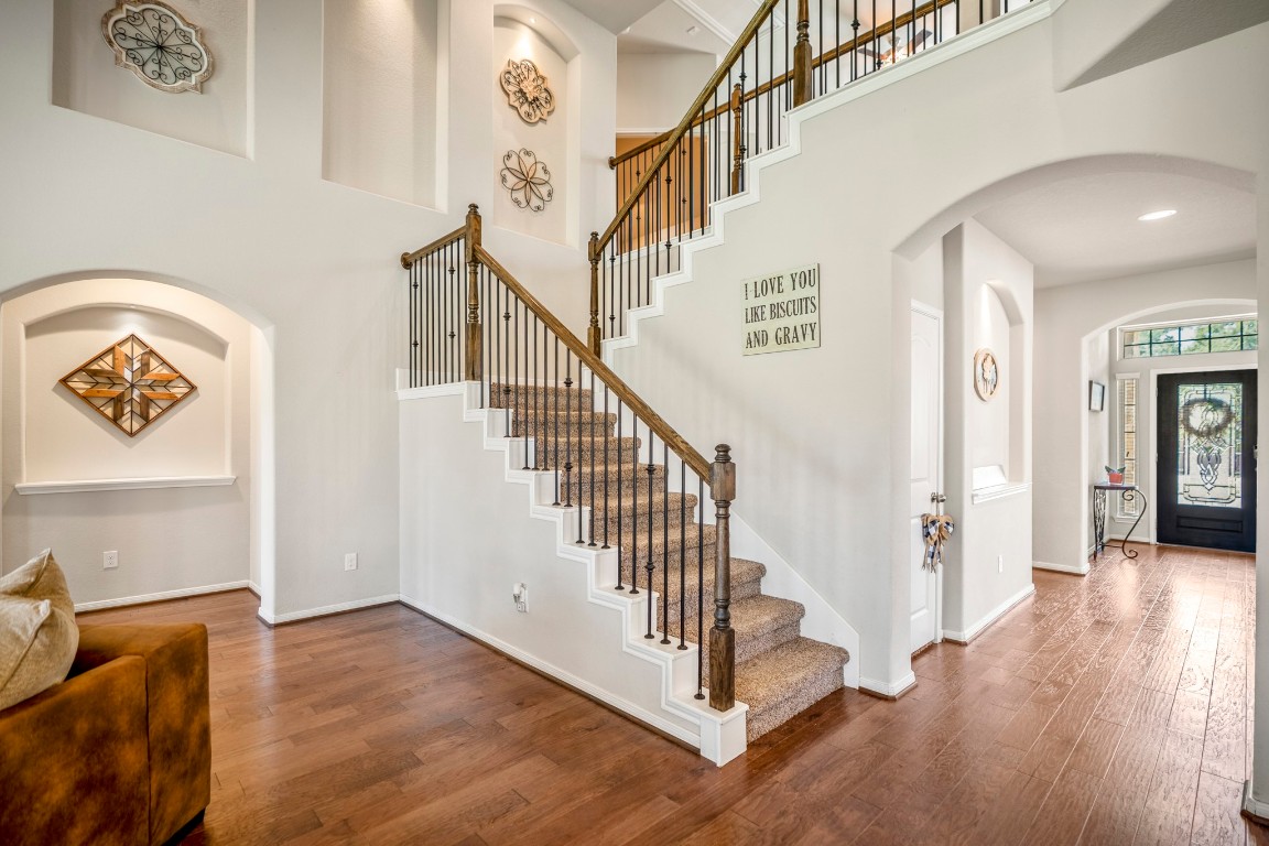 23006 Mulberry Tree Lane Spring, TX 77389 - Photo 26 of 50 A graceful staircase with wrought-iron railing leads to the upstairs game room, media room, and secondary bedrooms. To the left of the stairs we can see the arched doorway back to the primary suite.