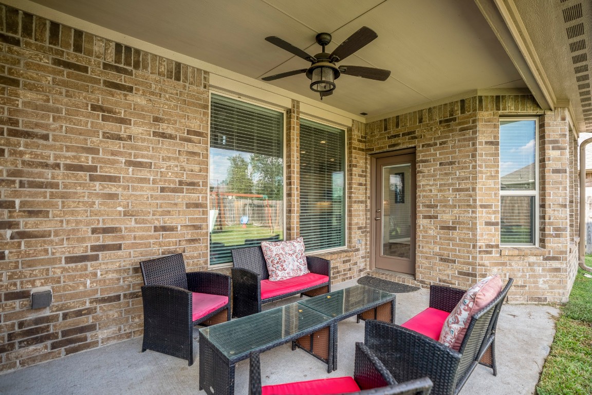 23006 Mulberry Tree Lane Spring, TX 77389 - Photo 39 of 50 Shaded patio with ceiling fan and room for outdoor seating—an easy extension of the living space for morning coffee or evening gatherings.