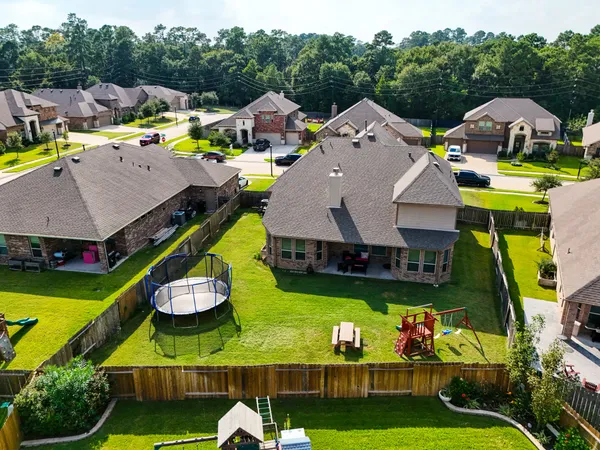 an aerial view of a house with a yard and a large tree
