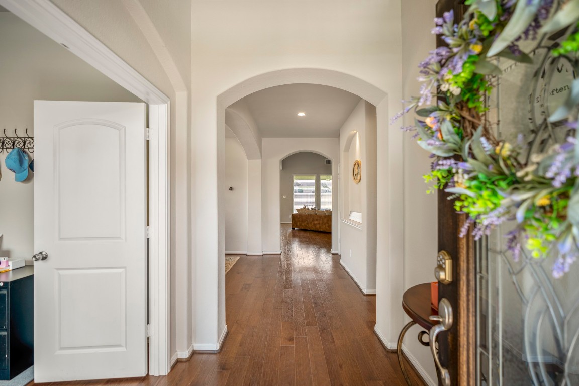 23006 Mulberry Tree Lane Spring, TX 77389 - Photo 5 of 50 Step inside to a bright foyer with arched openings and hardwood floors, where a study opens to the left, the formal dining sits beyond, and the living and kitchen spaces await just past the staircase.