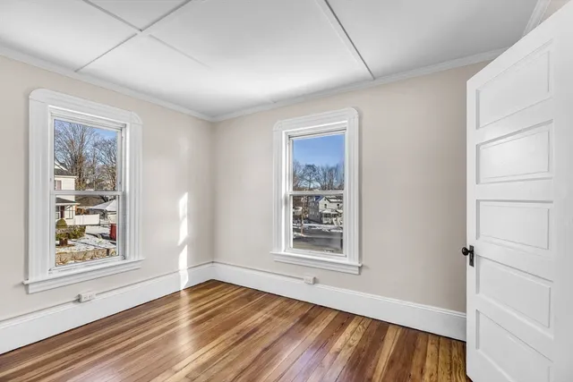 a view of a room with wooden floor and window