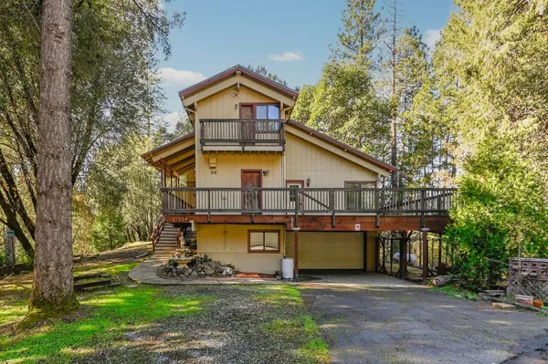 a view of a house with a yard patio and a tree