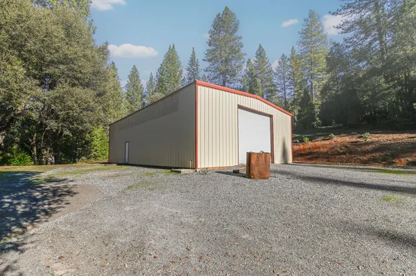 a view of a house with backyard and trees
