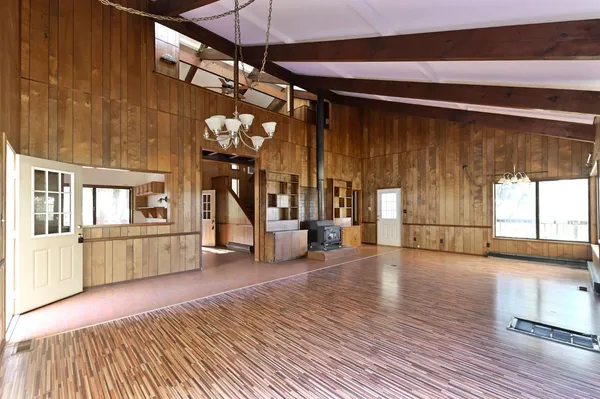 a view of a livingroom with wooden floor and stairs