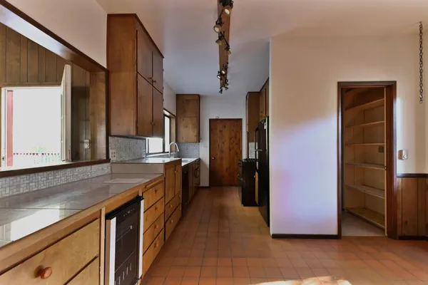 a kitchen with stainless steel appliances granite countertop a refrigerator a sink and a stove