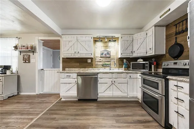 a kitchen with stainless steel appliances granite countertop a stove a sink and a refrigerator