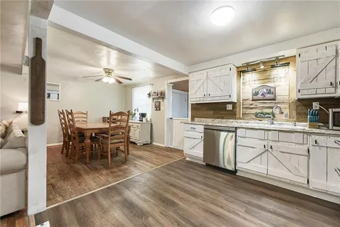 a kitchen with appliances cabinets and chair