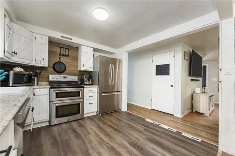 a kitchen with stainless steel appliances granite countertop a refrigerator and a stove top oven