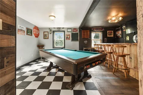 a room with pool table and glass windows