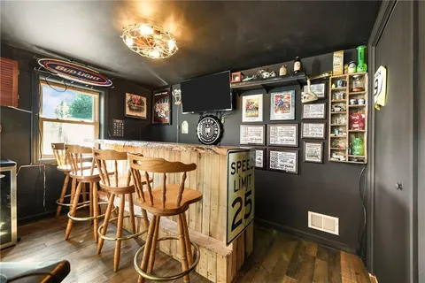 a view of a dining room with furniture a chandelier and window