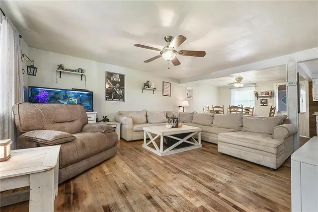 a living room with furniture and a ceiling fan