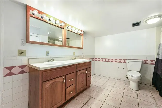 a spacious bathroom with a toilet sink and mirror