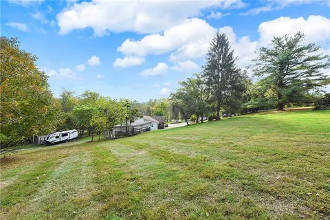 a view of a field of grass and trees