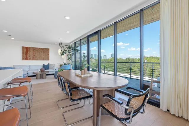 a dining room with furniture and a floor to ceiling window