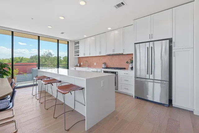 a kitchen with a refrigerator a white cabinets and outdoor space