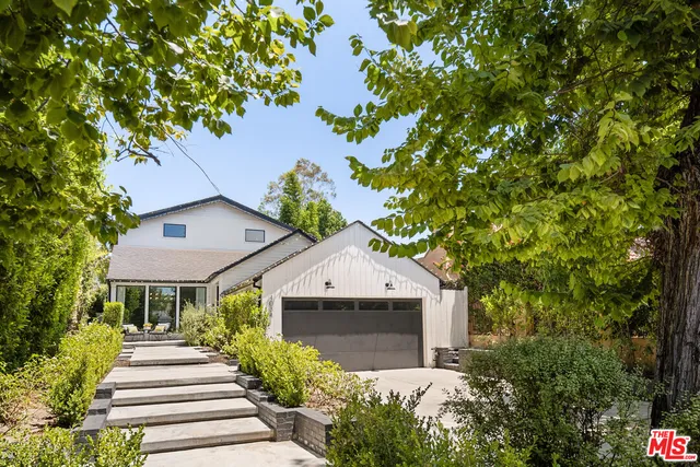 a front view of a house with a yard and fountain