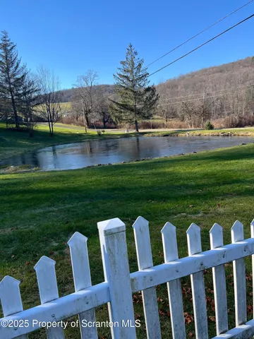 a view of a wooden chairs and table in the garden