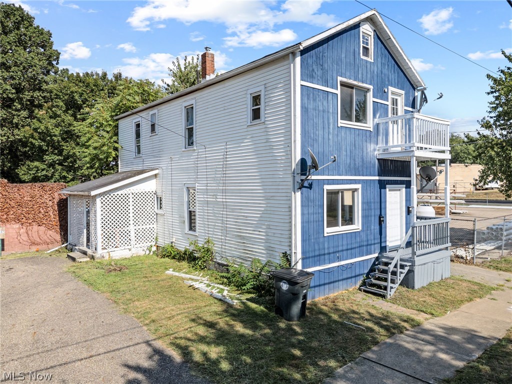 2387 29th Street Southwest Akron, OH 44314 - Photo 1 of 24 View of home's exterior with a chimney, a lawn, and a balcony