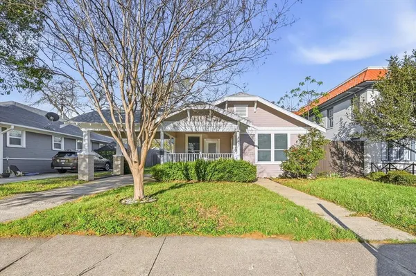 a front view of a house with a garden and trees