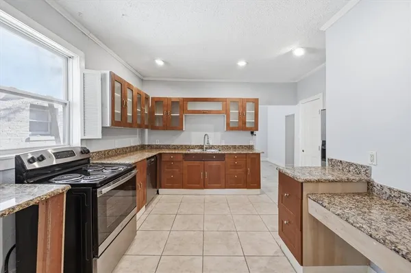 a kitchen with stainless steel appliances granite countertop a stove a sink and a microwave