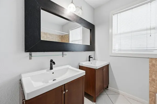 a bathroom with 2 sink and a mirror