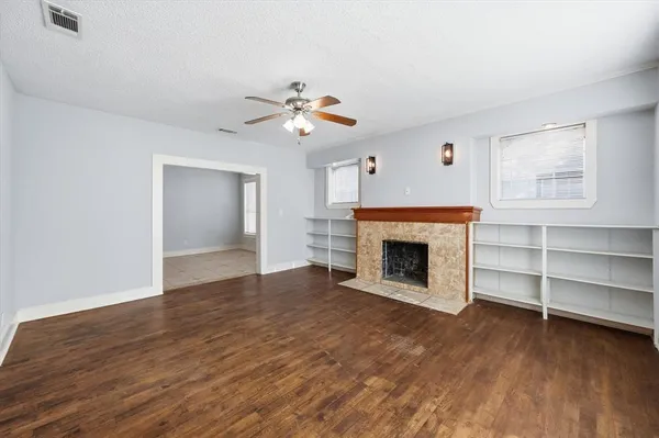 a view of an empty room with a fireplace and a window