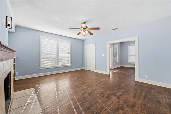 a view of a room with a ceiling fan window and hardwood floor