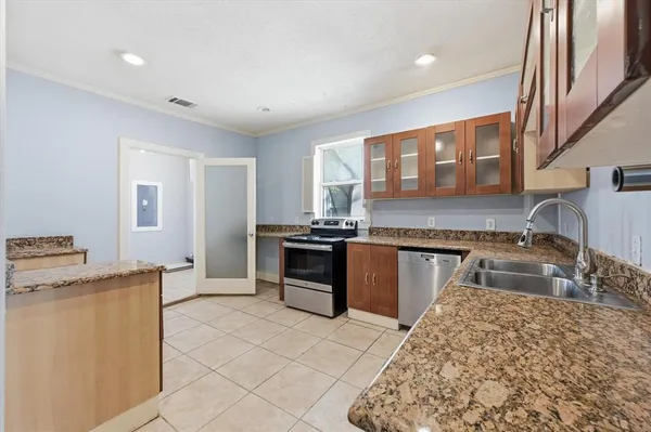 a kitchen with granite countertop a sink stove and refrigerator