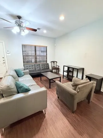 a living room with furniture kitchen view and a chandelier