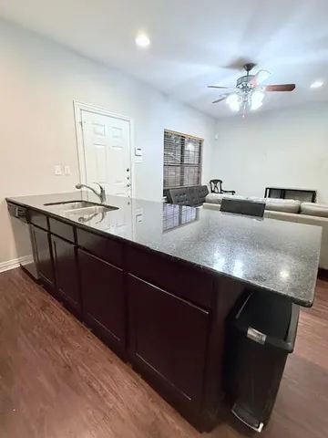 a kitchen with stainless steel appliances granite countertop a refrigerator a sink a stove a dining table and chairs