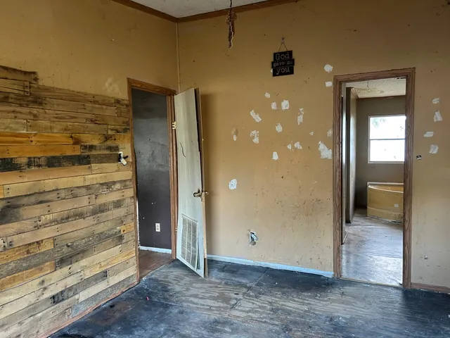 wooden floor in an empty room with a bathroom
