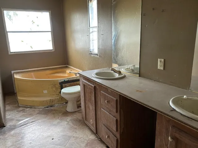 a bathroom with a granite countertop sink a toilet and a bathtub