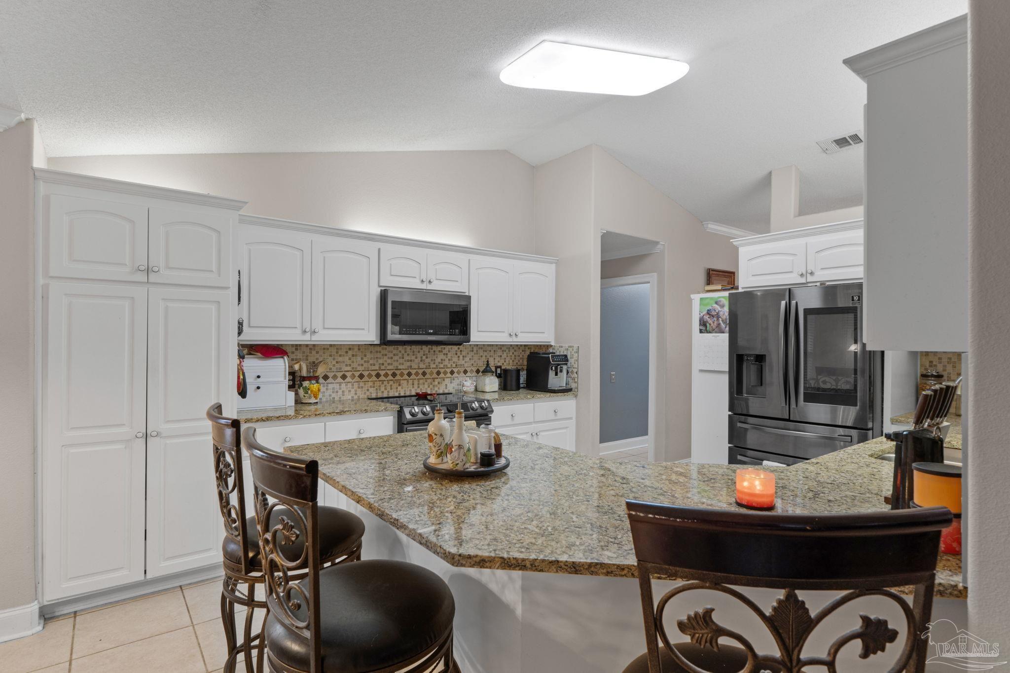 5692 Als Way Milton, FL 32583 - Photo 17 of 68 a kitchen with stainless steel appliances a table and chairs in it