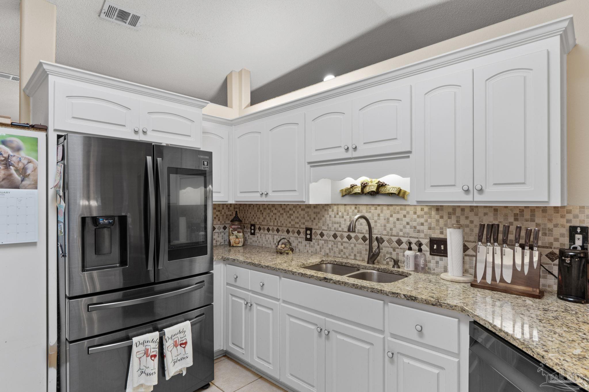 5692 Als Way Milton, FL 32583 - Photo 19 of 68 a kitchen with granite countertop a refrigerator and cabinets