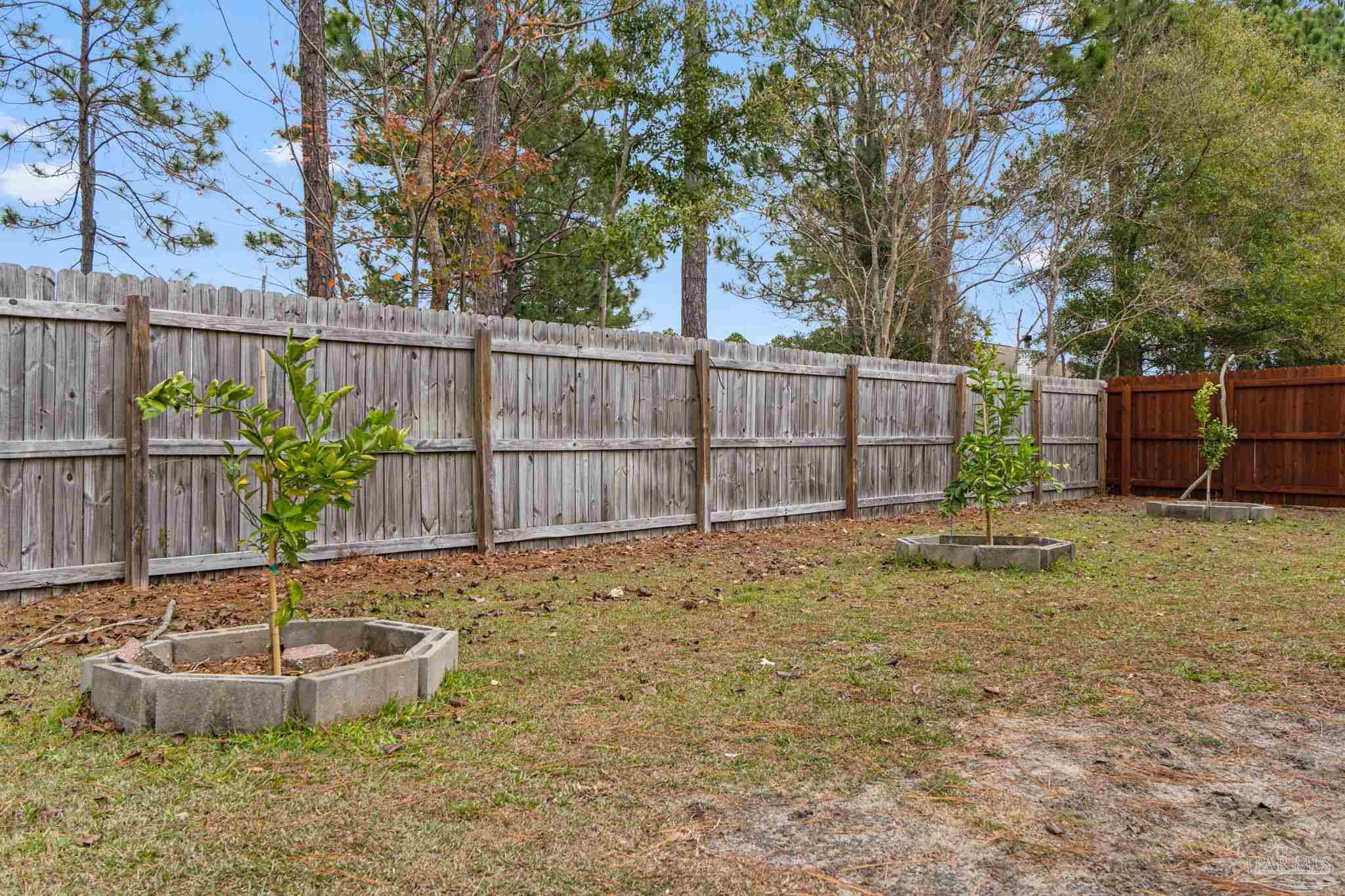 5692 Als Way Milton, FL 32583 - Photo 42 of 68 a view of a backyard with plants and wooden fence