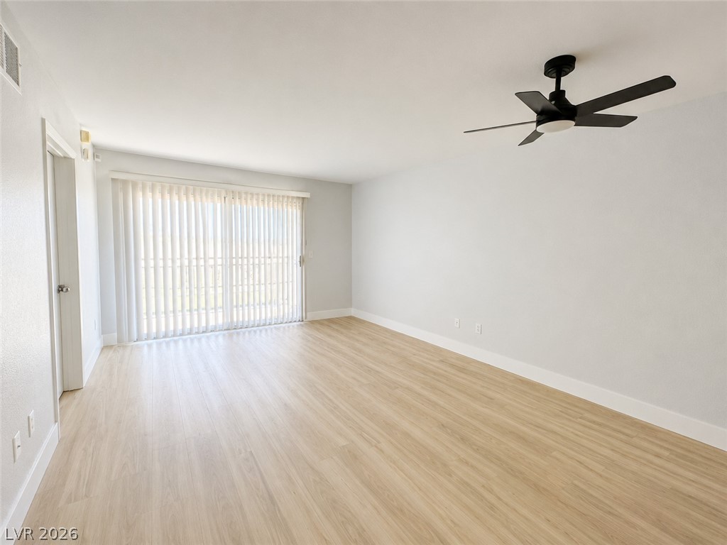 8070 West Russell Road, Unit 2023 Las Vegas, NV 89113 - Photo 2 of 6 A versatile living area features sleek laminate flooring and a cooling ceiling fan.