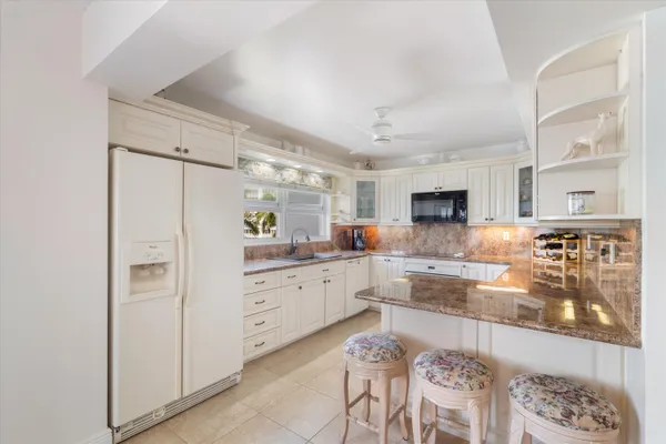 a kitchen with kitchen island white cabinets and stainless steel appliances