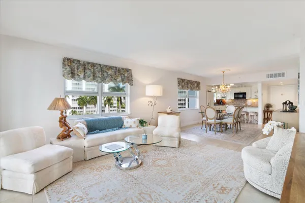 a dining room with furniture wooden floor a chandelier and a painting