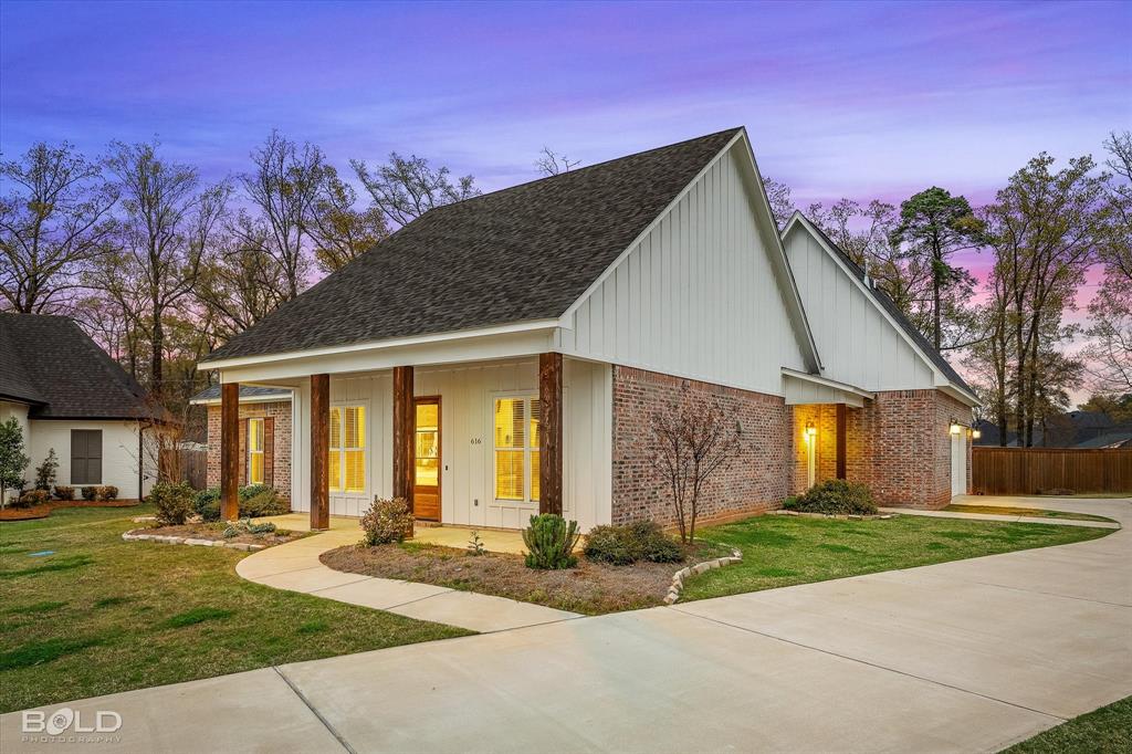 a front view of a house with a yard and trees