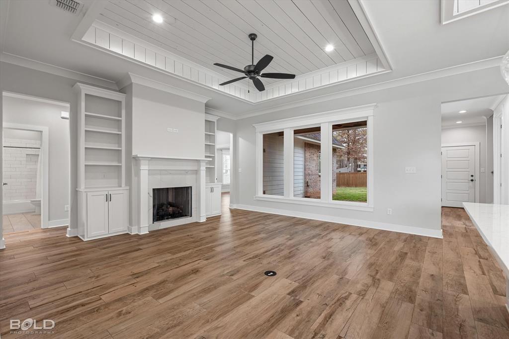 616 Meridian Way Benton, LA 71006 - Photo 14 of 40 a view of an empty room with wooden floor fireplace and a window